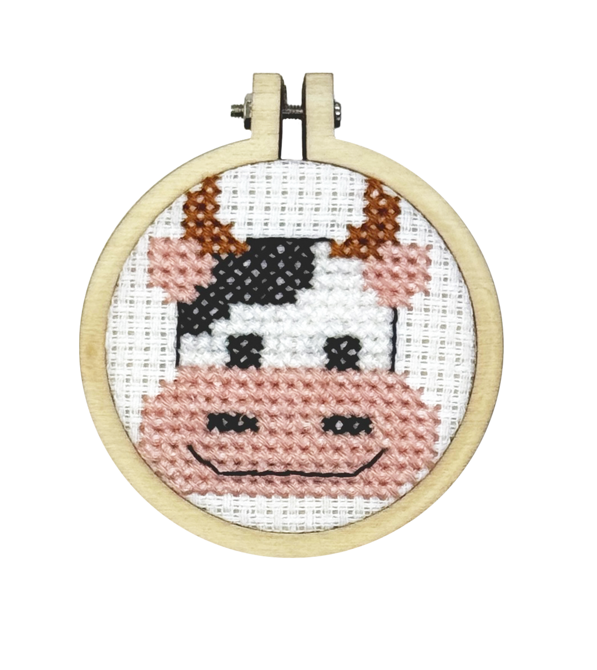 Finished black and white cow face cross stitch in a 5cm wooden hoop