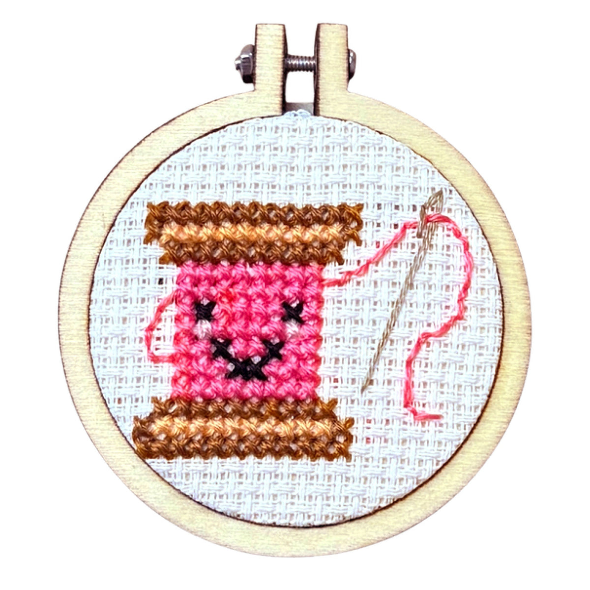 Finished smiling pink cotton reel cross stitch in a 5cm wooden hoop