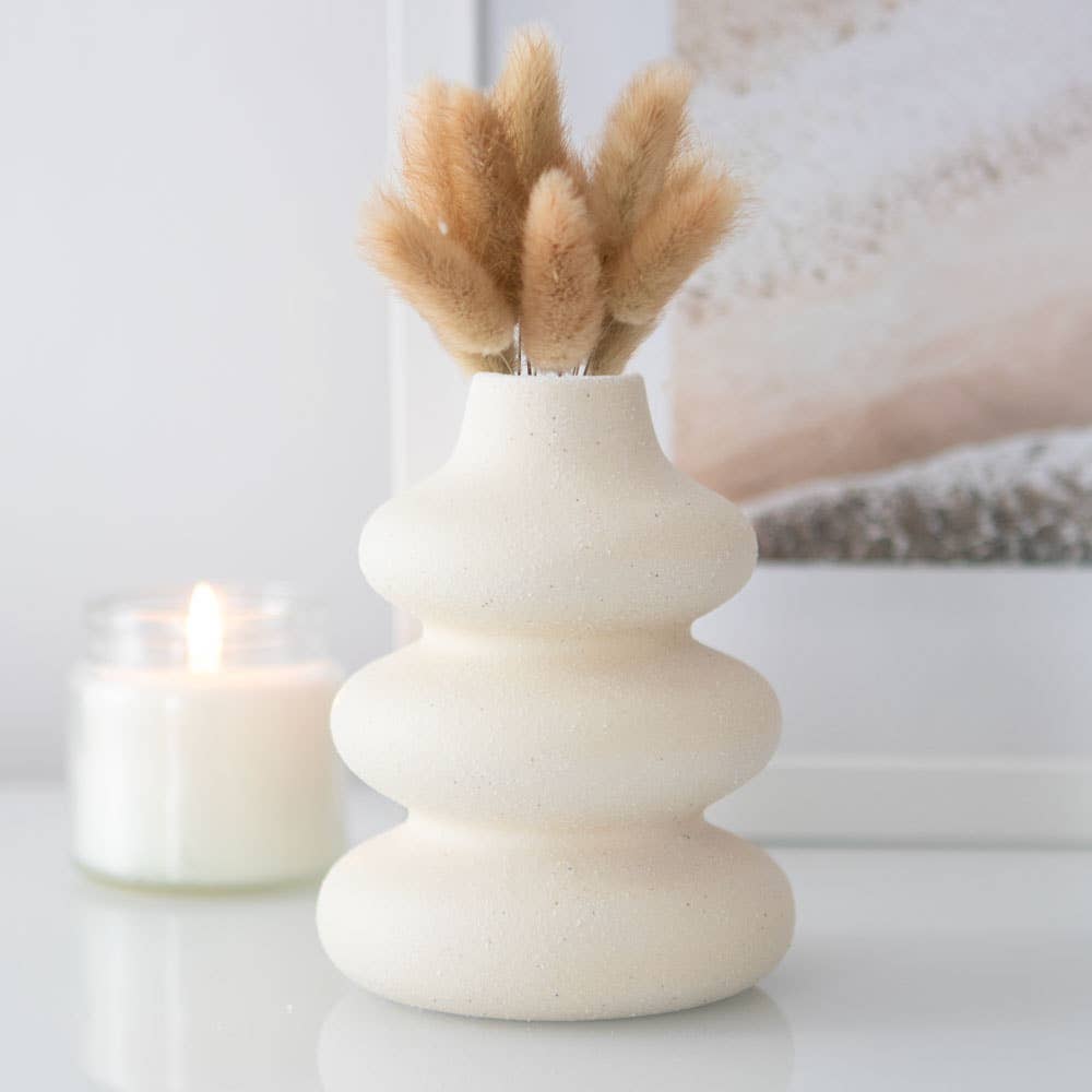 Cream speckle single stem vase with modern wavy stacked bubble design holding dried grass