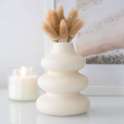 Cream speckle single stem vase with modern wavy stacked bubble design holding dried grass