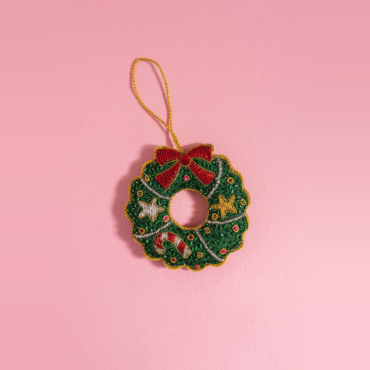 Christmas Wreath embroidered decoration, green with red bow and gold stars, on a pink background