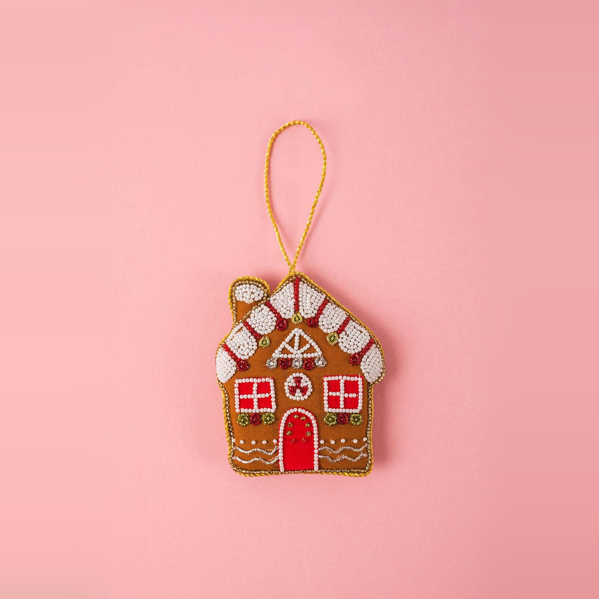 Gingerbread House embroidered Christmas decoration with white beaded icing and red door on a pink background