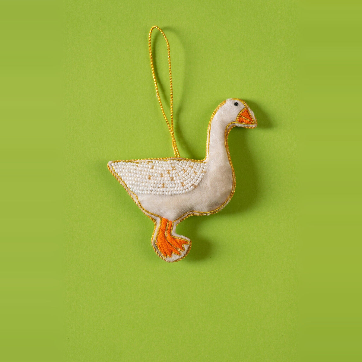 Goose embroidered Christmas decoration, white beaded body with orange feet, on a green background