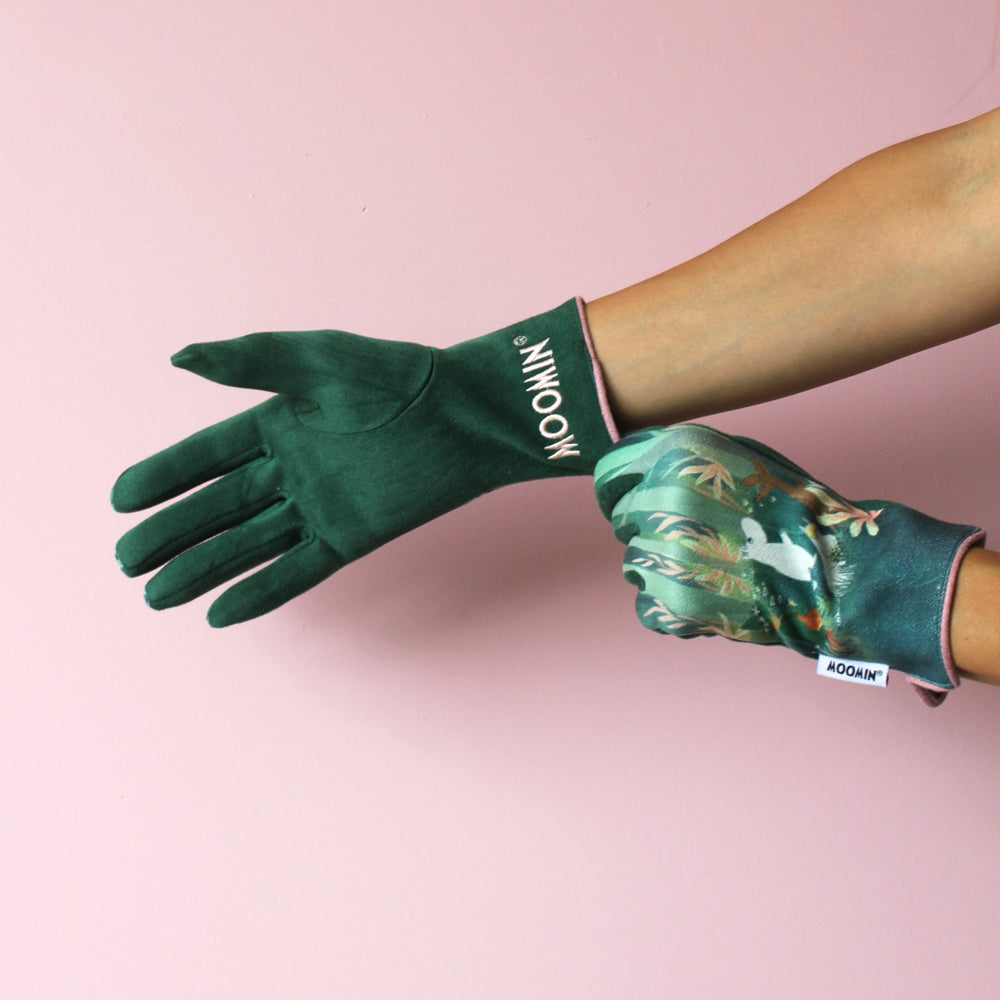 Moomin Forest Gloves worn on a hand and held against a pink background
