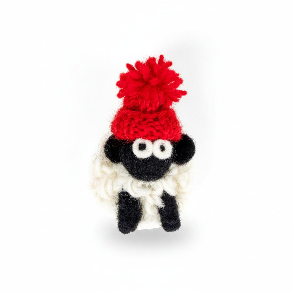 Hand-knitted wool sheep fridge magnet wearing a red bobble hat