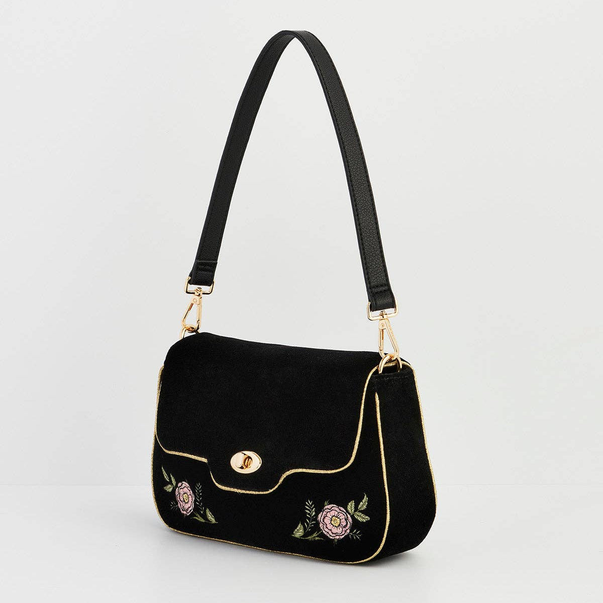Black velvet rose embroidered bag with black strap on grey background