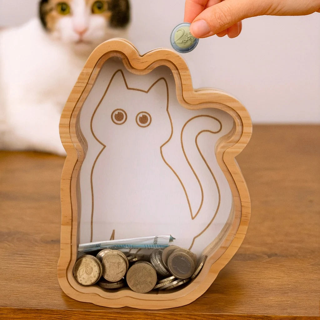Hand dropping a coin into the top of the wooden cat money box