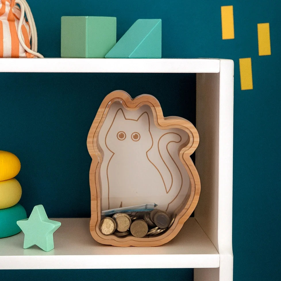 Cat money box standing on a white shelf against a dark blue wall