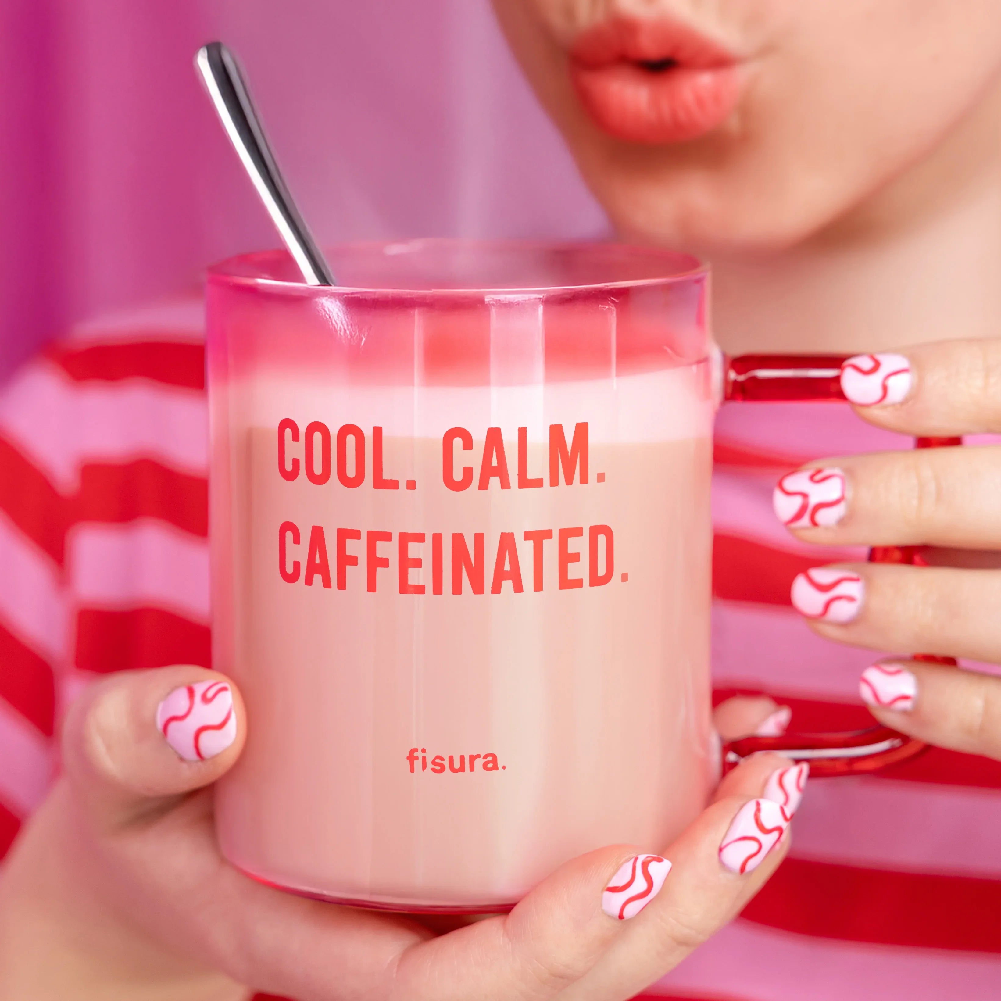 Person holding the pink glass mug against a pink gingham background