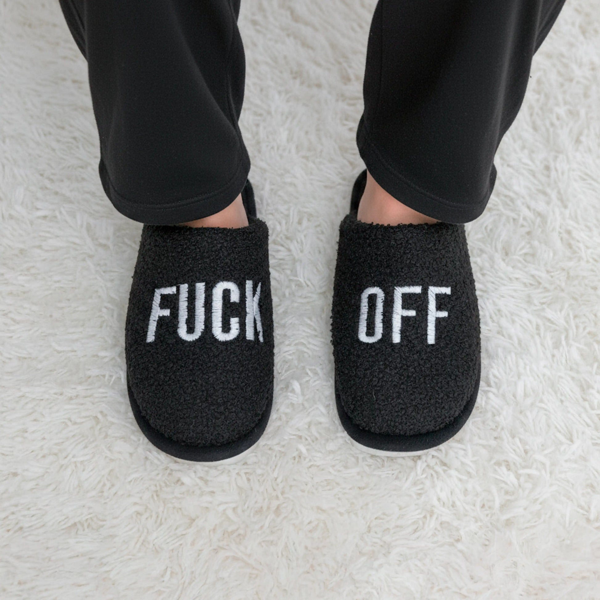 Person wearing the black slippers with black loungewear