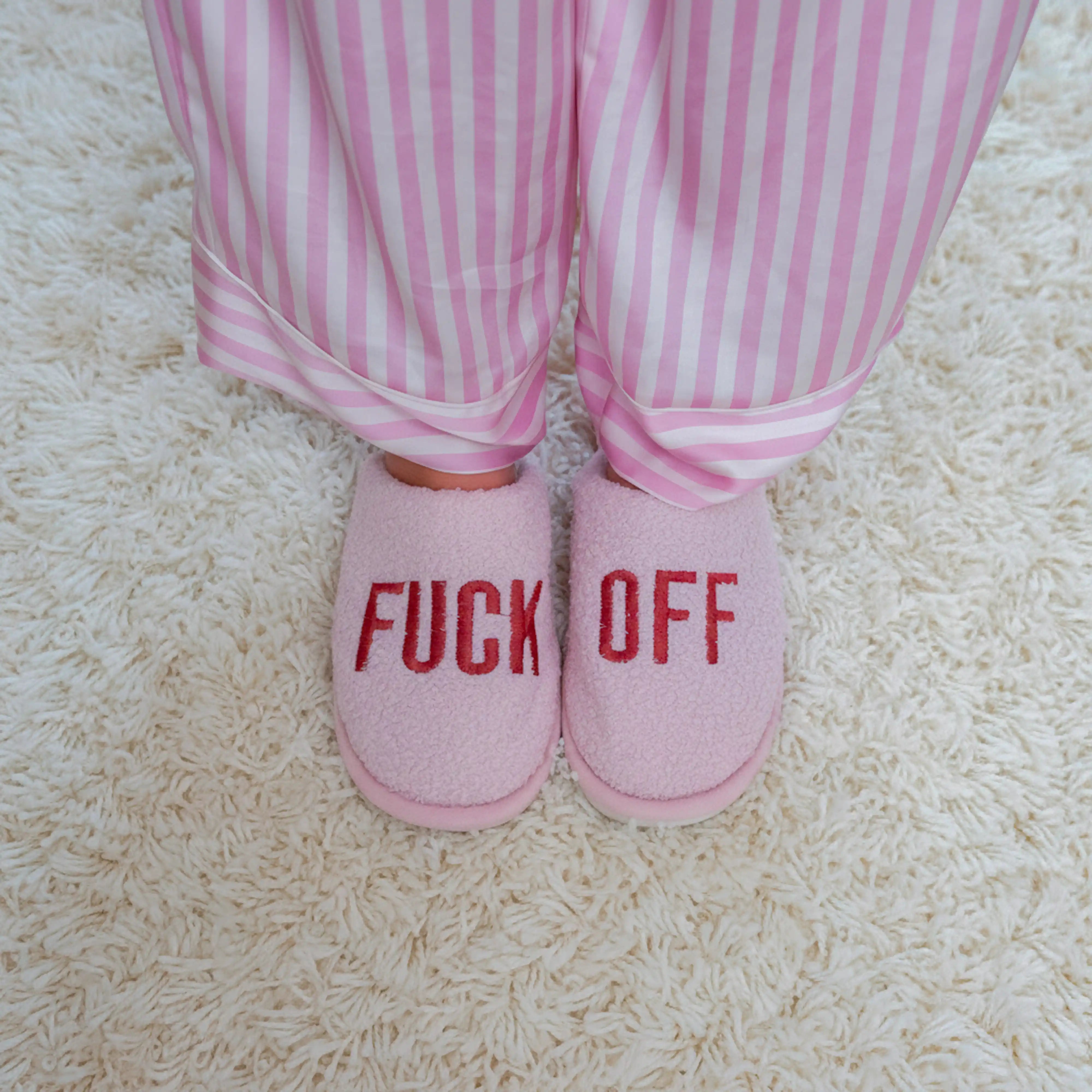 Person wearing the pink slippers with striped pink pyjamas