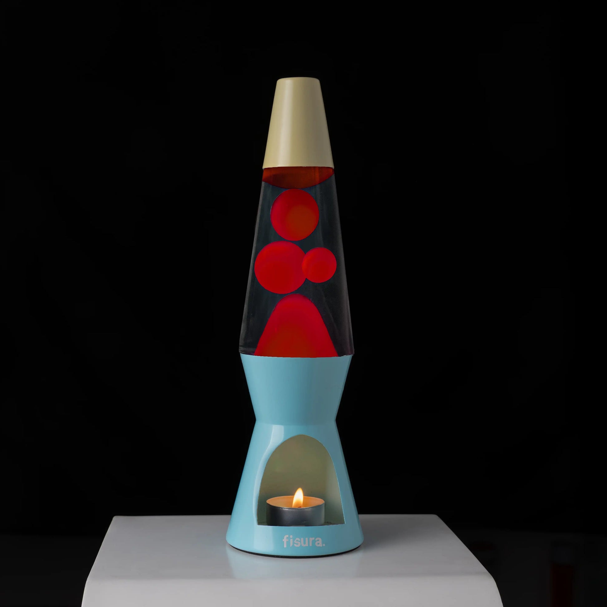 Blue and beige lava candle lamp glowing against a black background