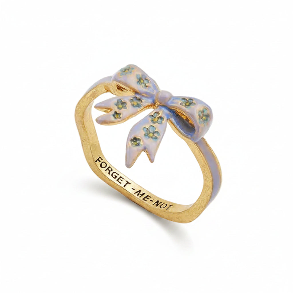 Forget-Me-Not bow ring in gold with blue enamel on white background.