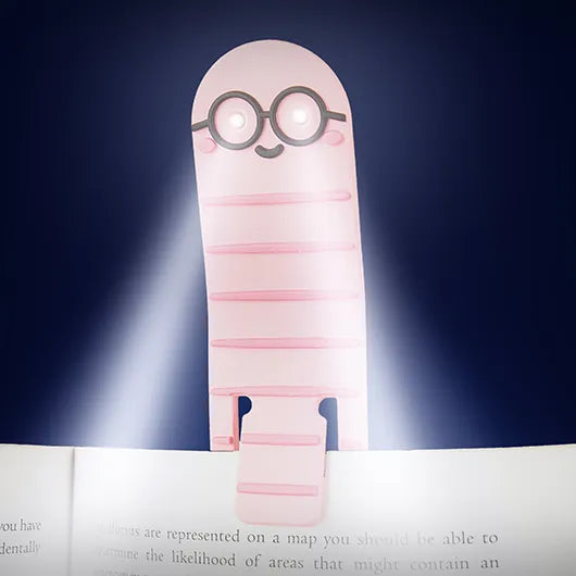 Bookworm reading light shining onto a book page in the dark