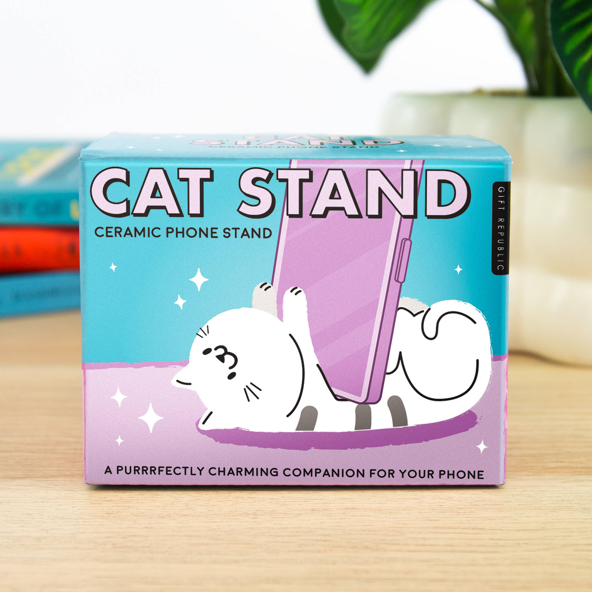 Cat Stand ceramic phone stand box on a wooden table with plants