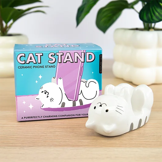 White ceramic cat phone stand beside its box on a wooden table