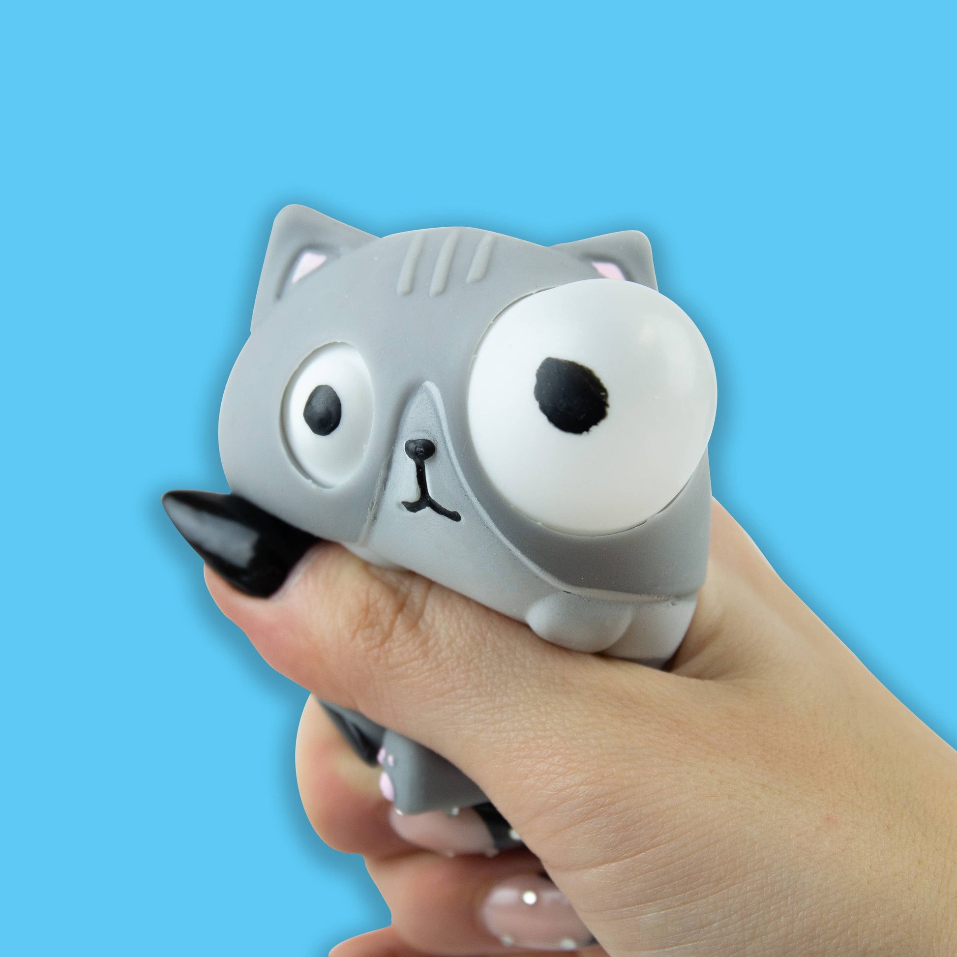 Grey cat stress toy being squeezed so its eyes pop out