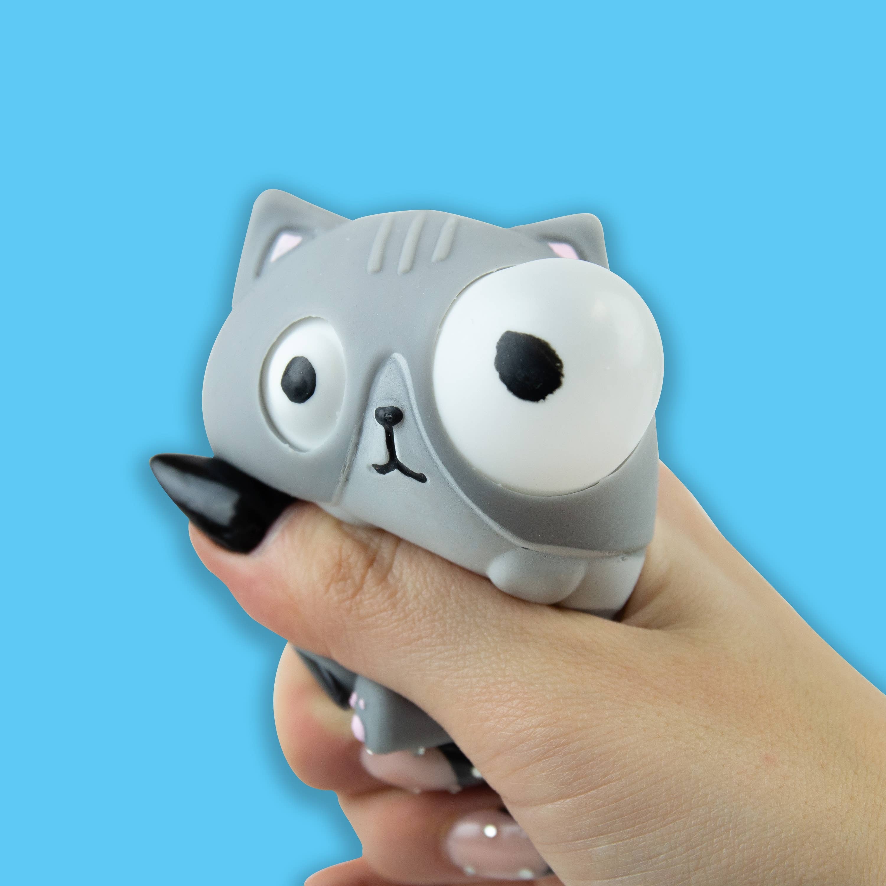 Grey cat stress toy being squeezed so its eyes pop out