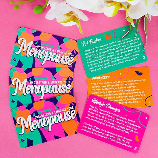 Menopause tip cards spread out on a pink background