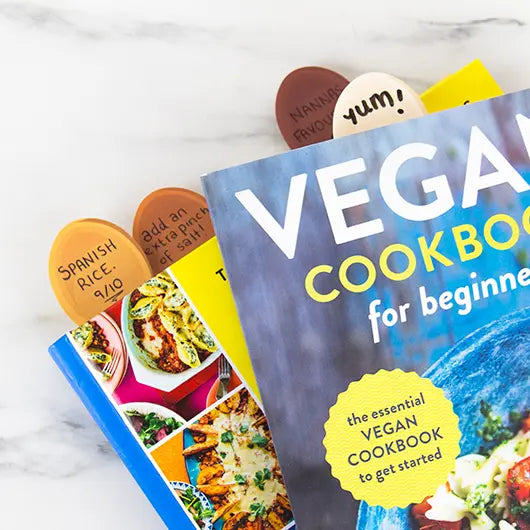 Recipe Keepers spoon markers sticking out of a stack of cookbooks