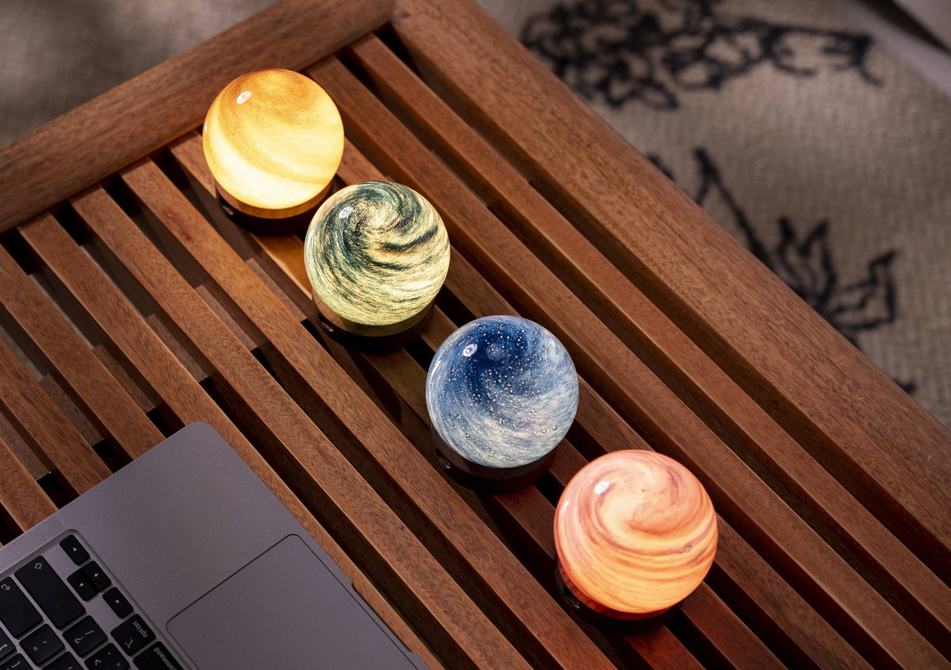 AstraGlass glass orbs unlit in four finishes on slatted wooden table
