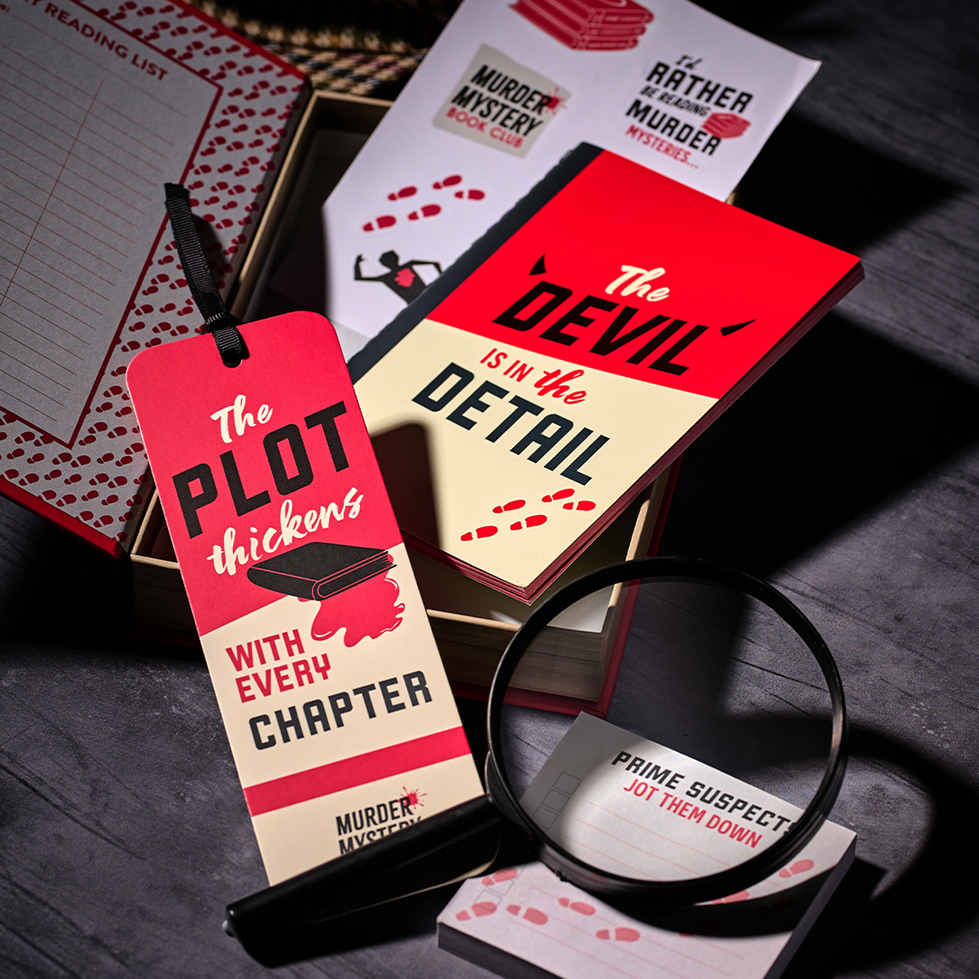 Stationery set contents styled with a magnifying glass and notebook