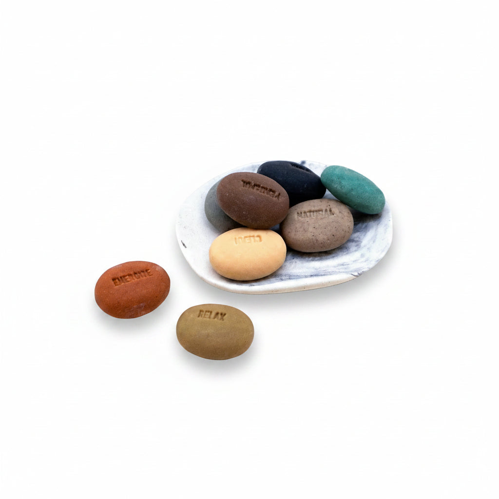 Mood soap pebbles and marbled porcelain dish on a white background