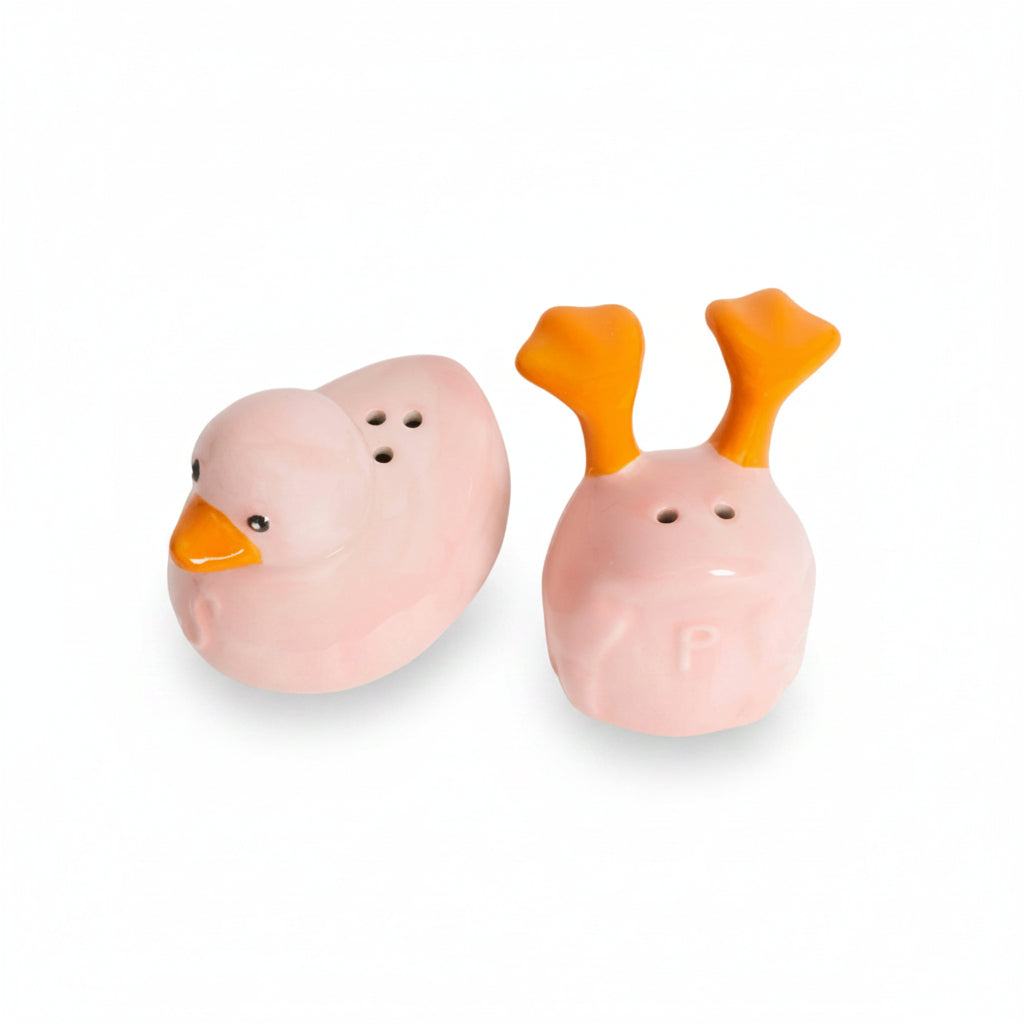 Pink duck salt and pepper shakers with orange beak and feet on white