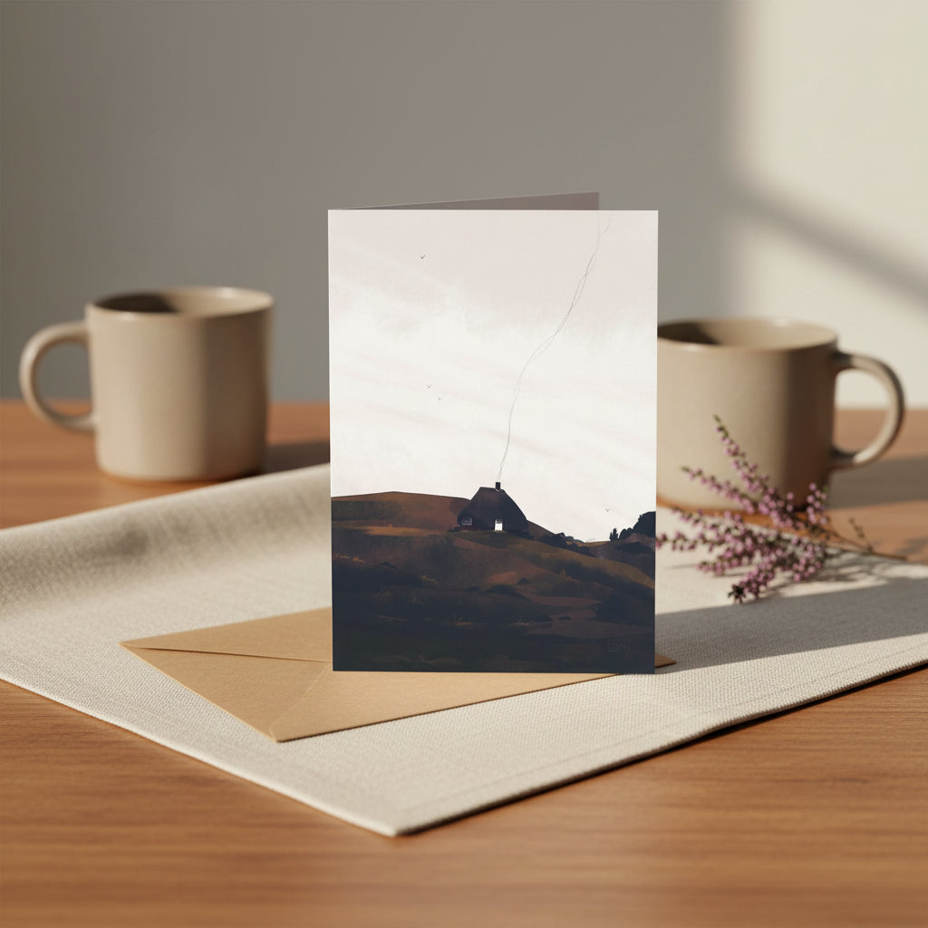A square art print card with a kraft envelope, featuring a minimalist landscape illustration of a small house on a hill under a pale sky.
