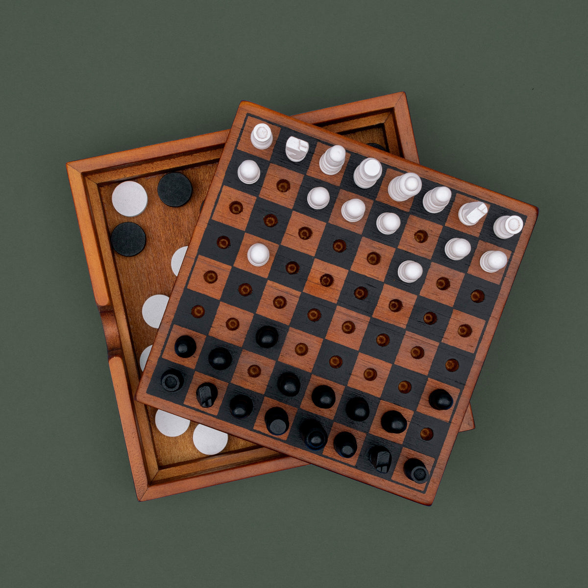 Checkmate wooden board set for checkers on its box, dark green background