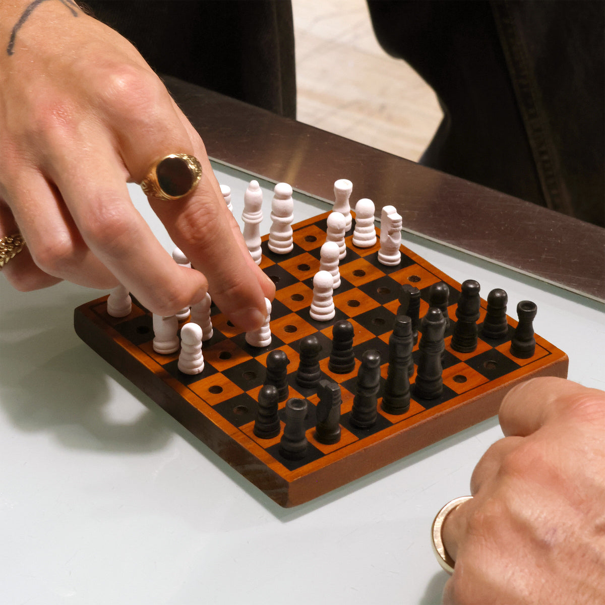 Two players mid game on the Iron & Glory Checkmate wooden chess board