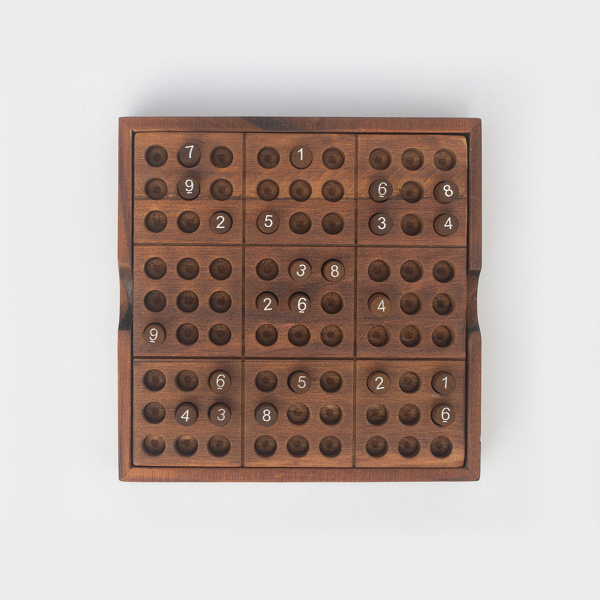 Iron & Glory wooden sudoku board, top down with numbered pegs, grey background