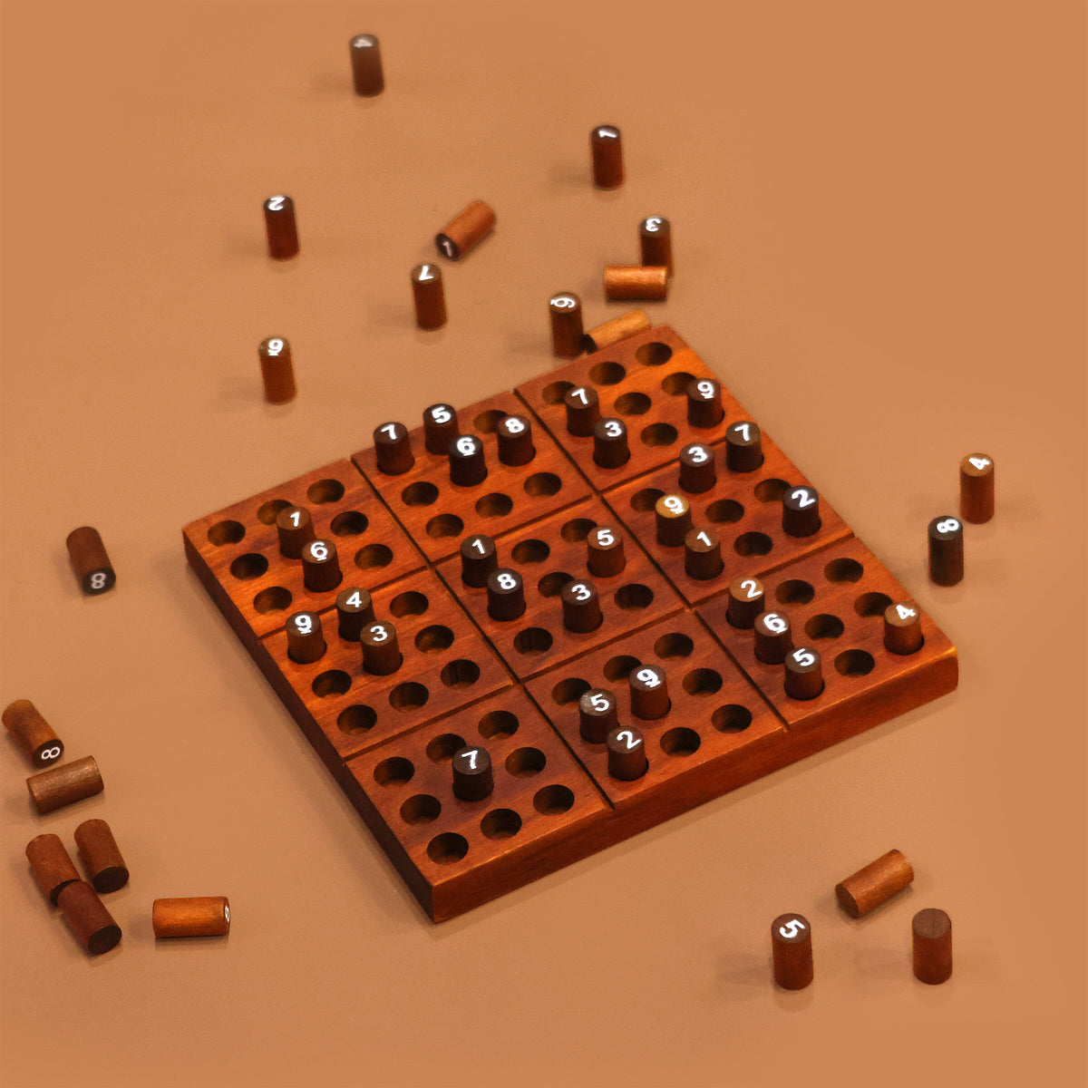Wooden sudoku board with scattered number pegs on a terracotta background