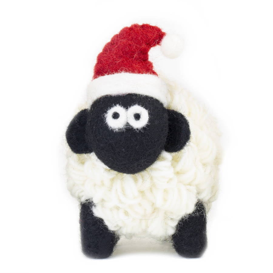 Handmade wool sheep in a red Santa hat with black face and legs, front view