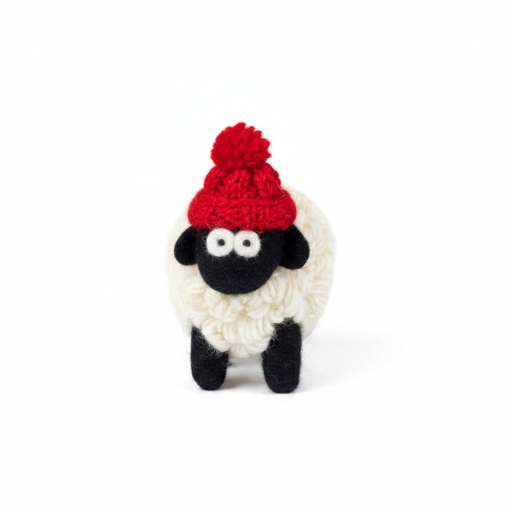 Hand-knitted wool sheep figure wearing a red bobble hat