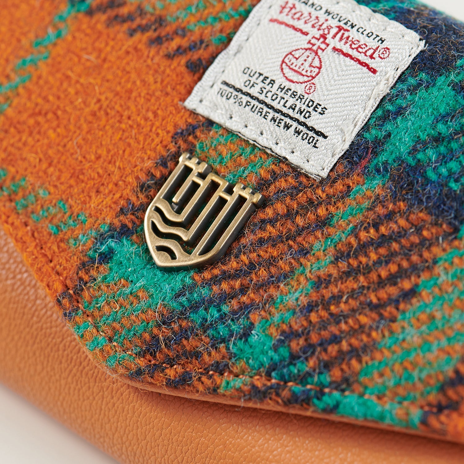 Close up of the orange and teal Harris Tweed with the orb label