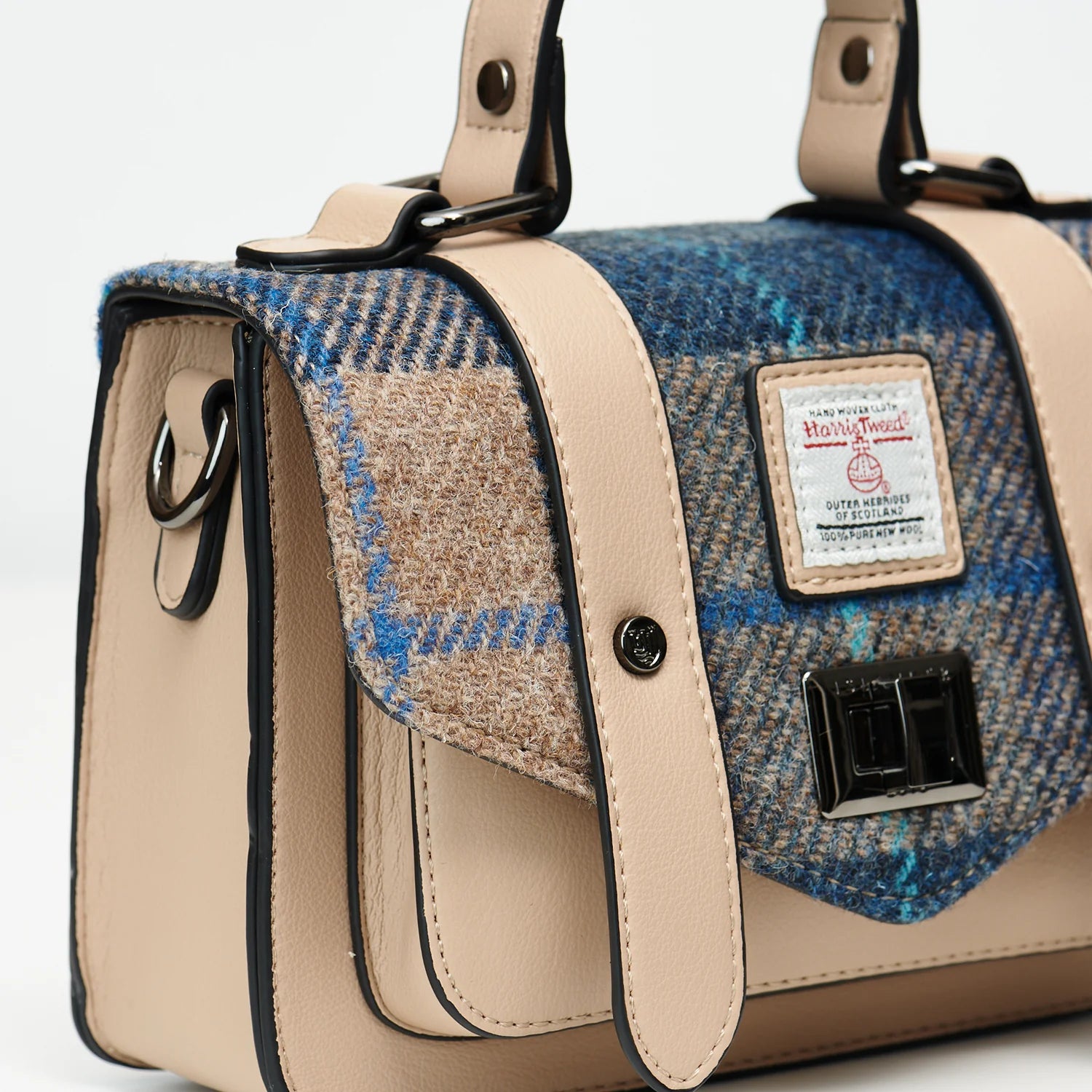 Close-up of Harris Tweed label and silver clasp on front flap of the satchel.