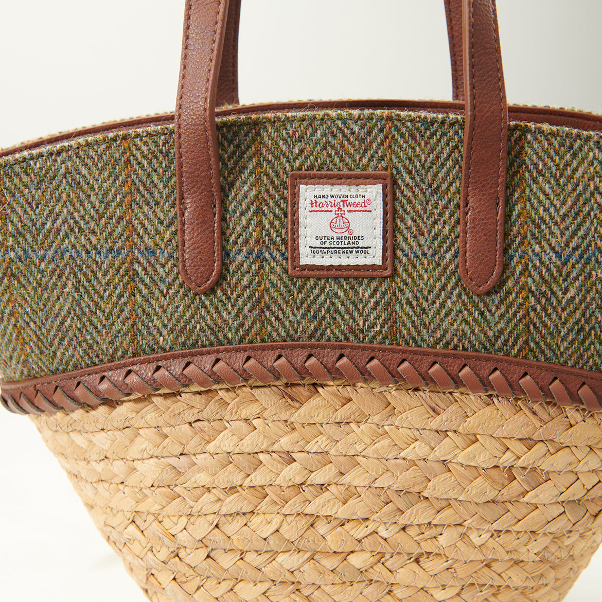 Detail of the Harris Tweed label and plaited leather trim on the basket