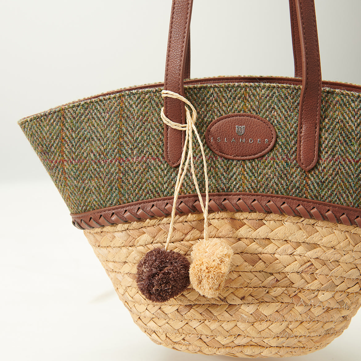 Close up of the herringbone tweed lid with two wool pom pom charms