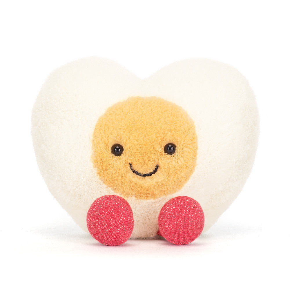 Front view of the heart-shaped Jellycat boiled egg plush sitting upright on white