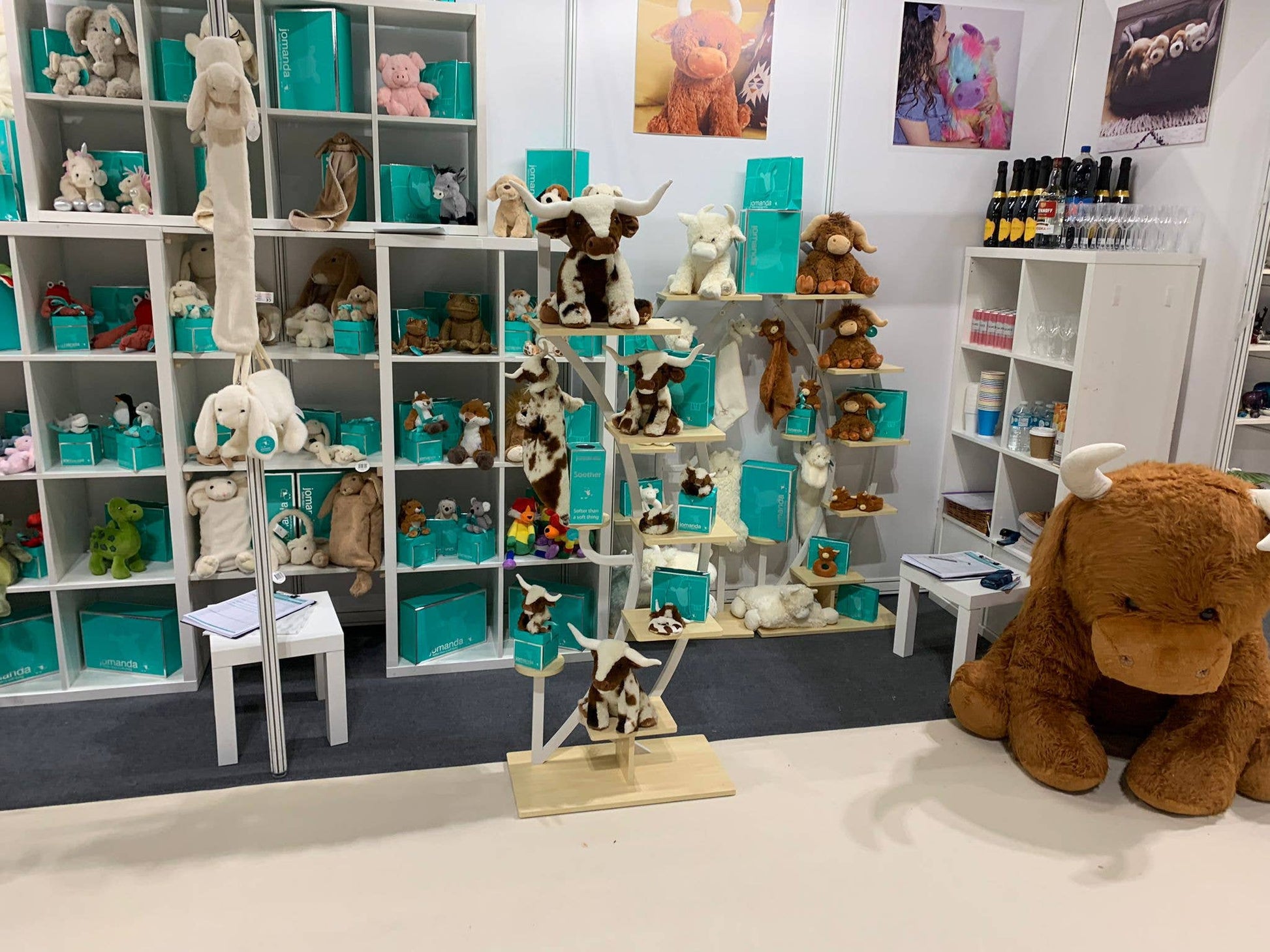 Jomanda display with giant highland cow plush and boxed toys