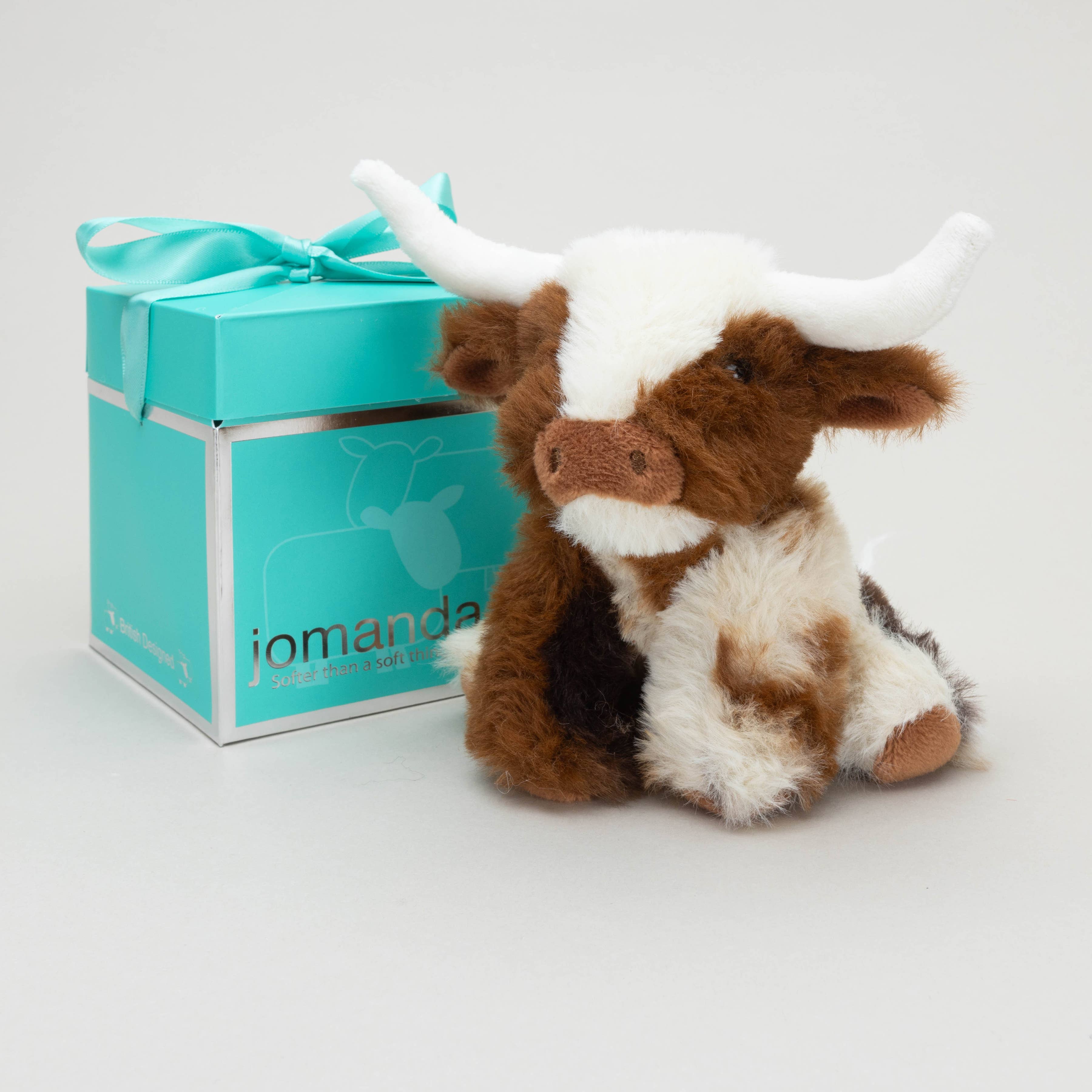 Texas Longhorn mini cow beside teal Jomanda gift box tied with ribbon