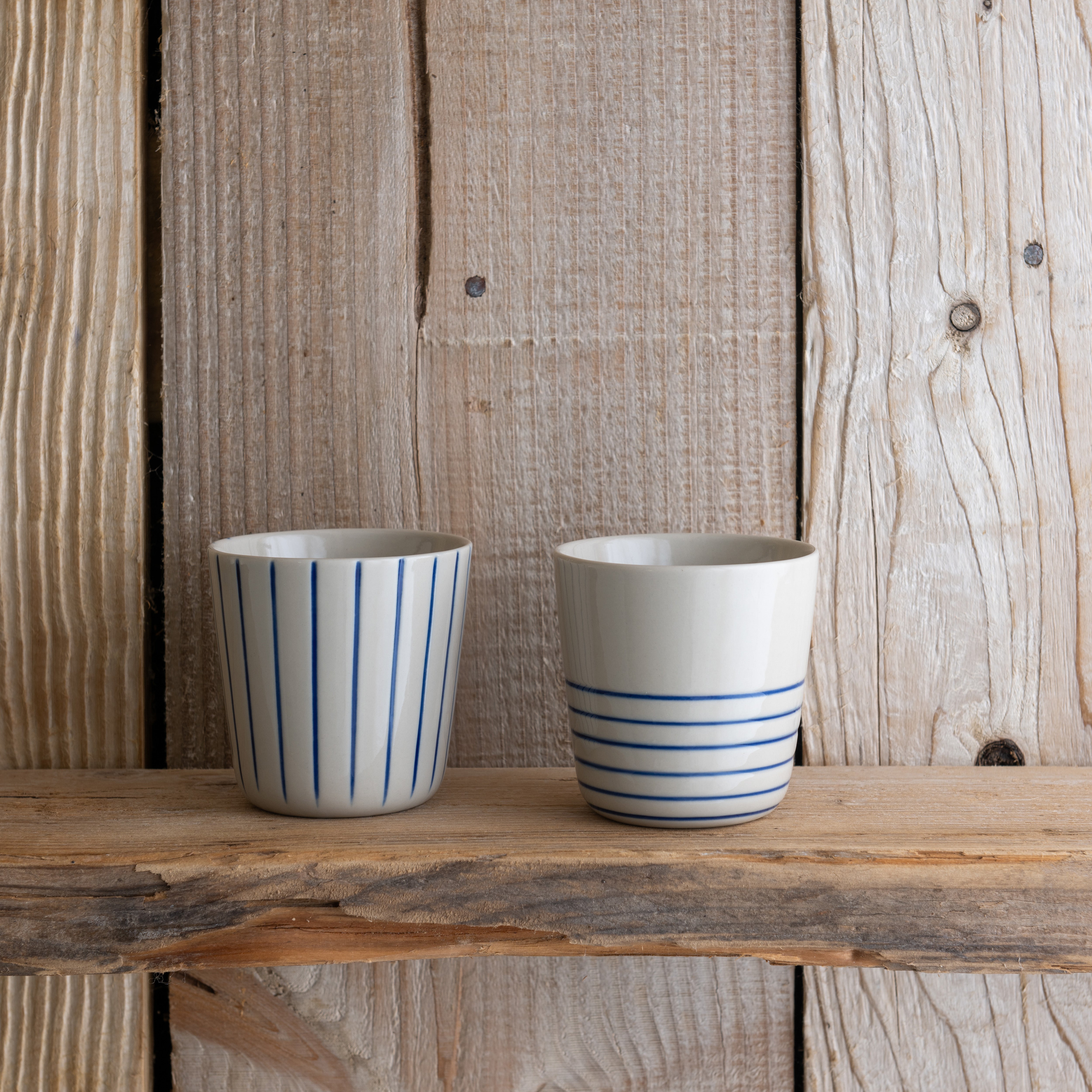 Small indigo blue Sorrel beakers on a rustic wooden shelf