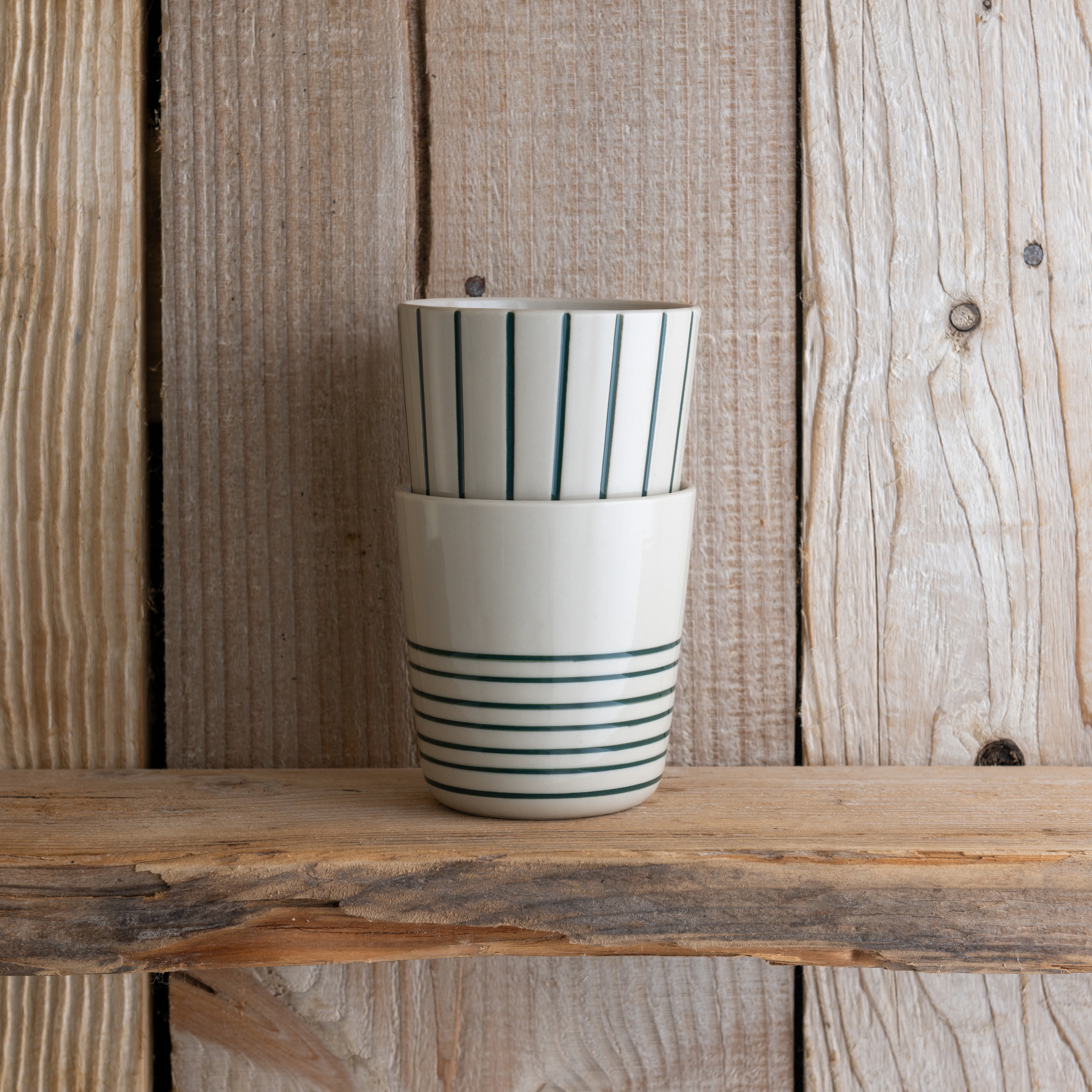 Sea green Sorrel beakers stacked on a weathered wooden shelf