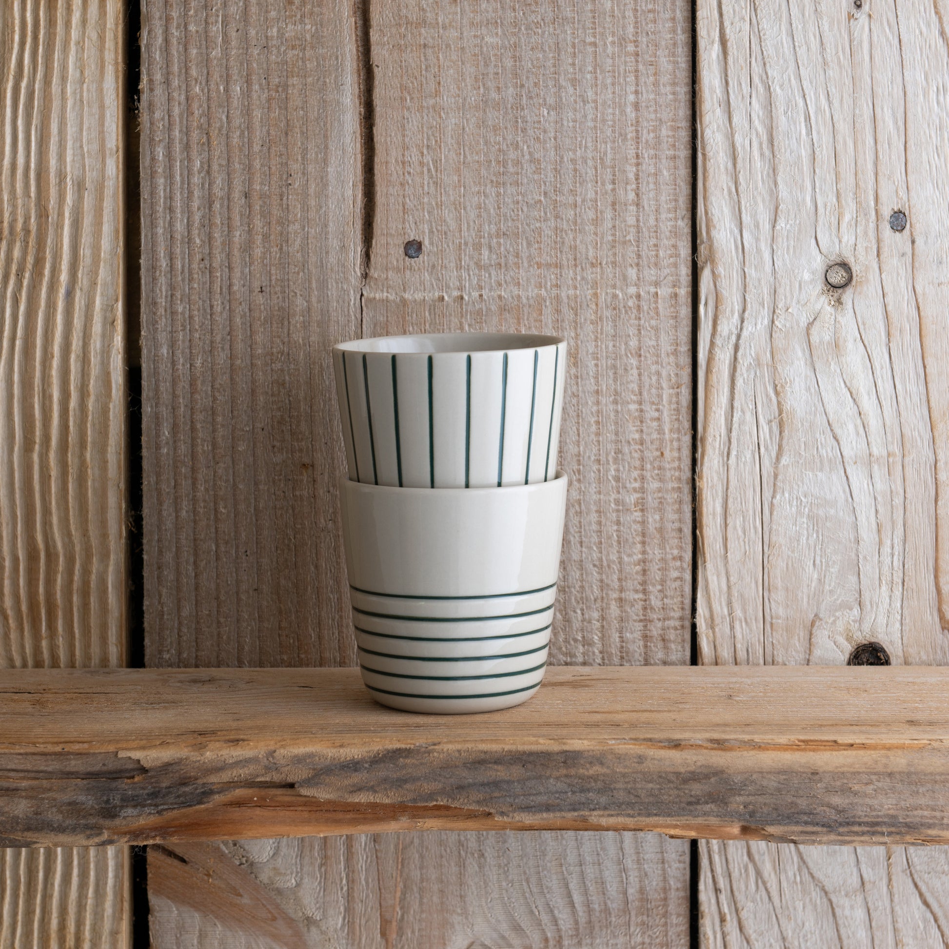 Small sea green Sorrel beakers stacked on a wooden shelf