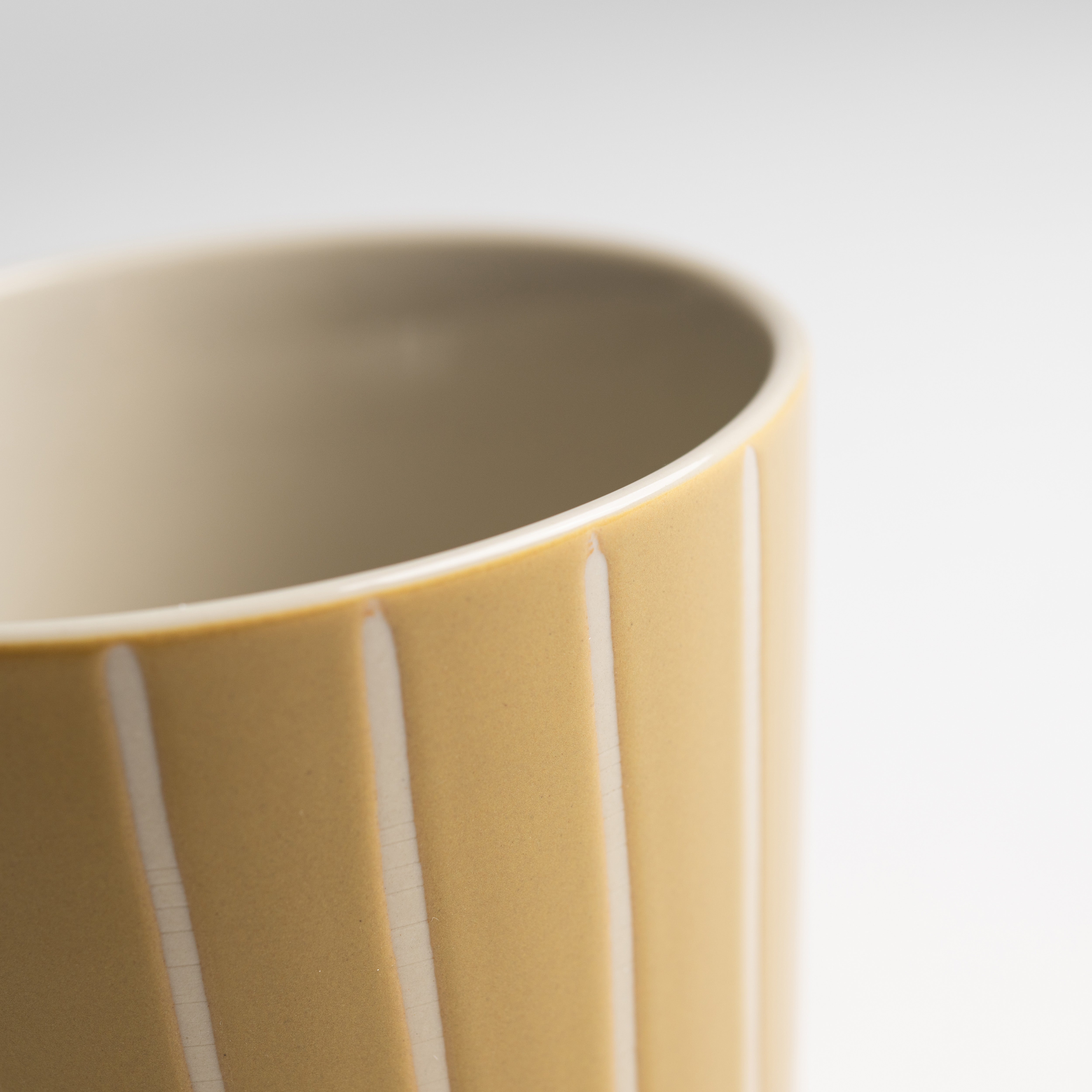 Close up of the etched lines and mustard glaze on a Vervain mug