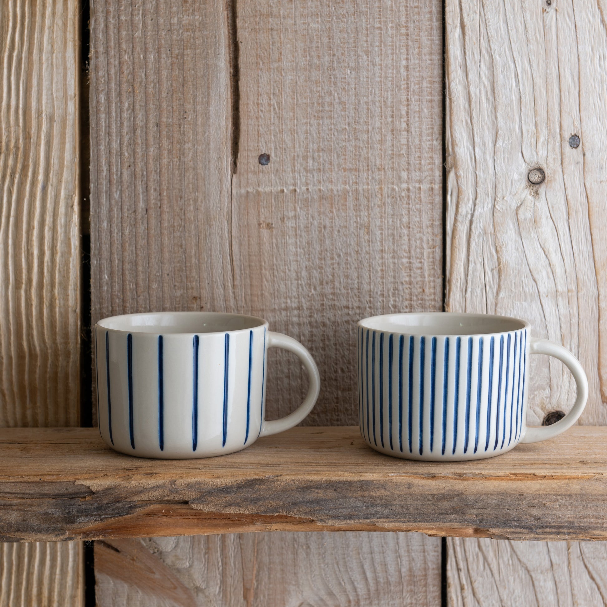 Indigo blue Yarrow mugs on a rustic wooden shelf