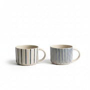 Two indigo blue hand-etched Yarrow mugs on a white background