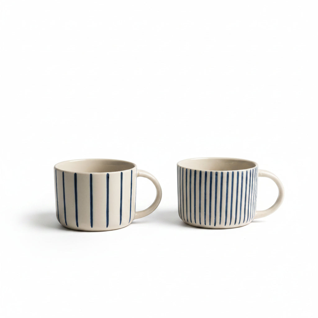 Two indigo blue hand-etched Yarrow mugs on a white background