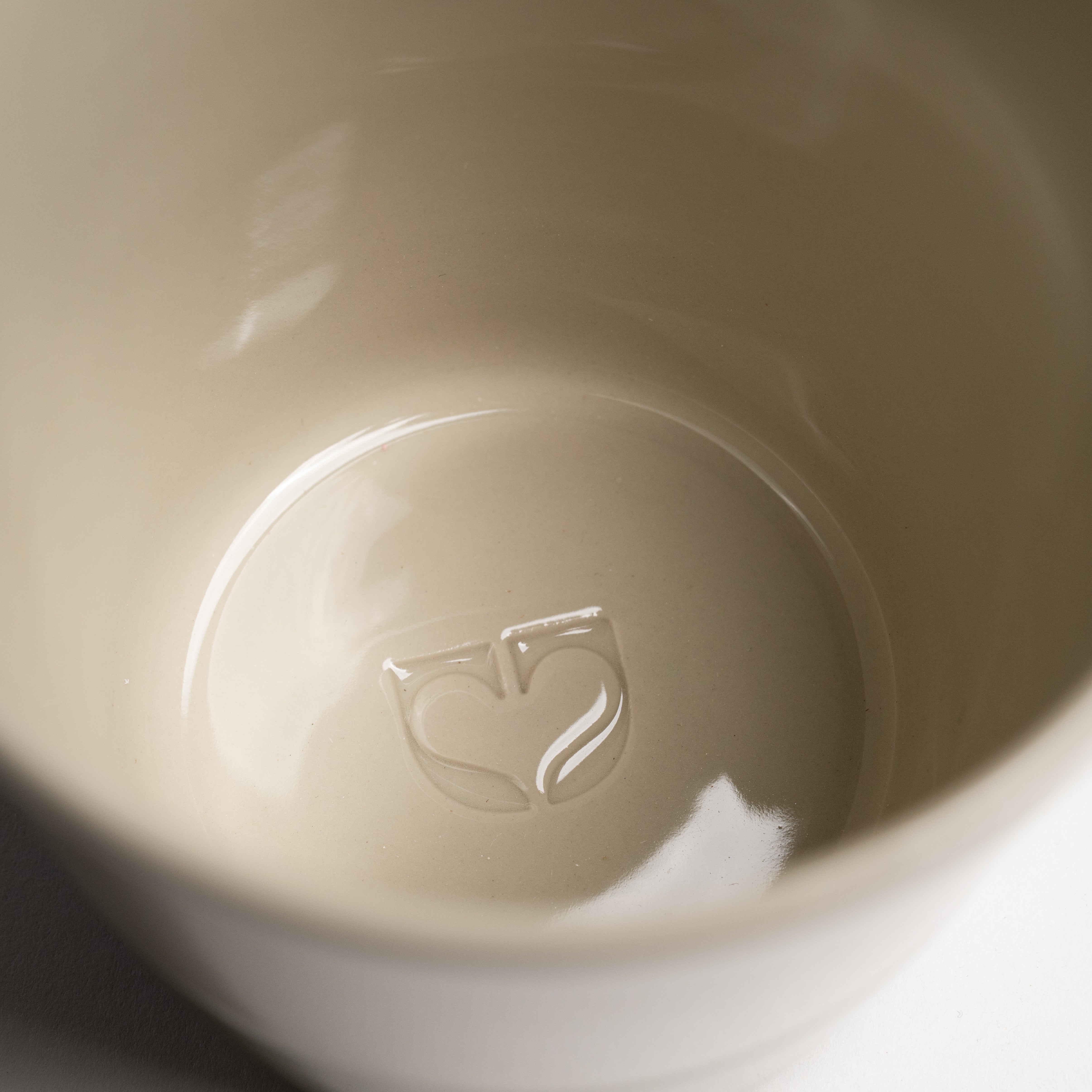 Close up of the Kindred icon embossed inside a Yarrow mug base